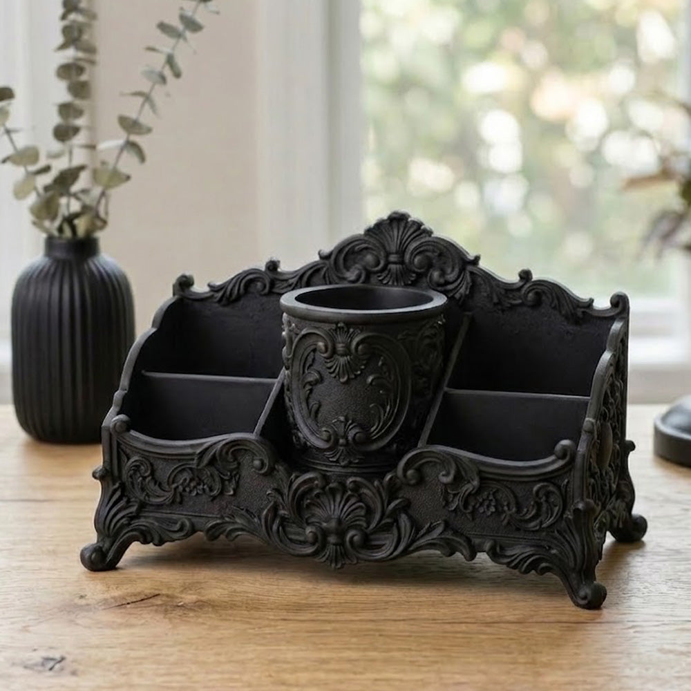 Close-up of black baroque desk organizer with decorative scrollwork and storage compartments
