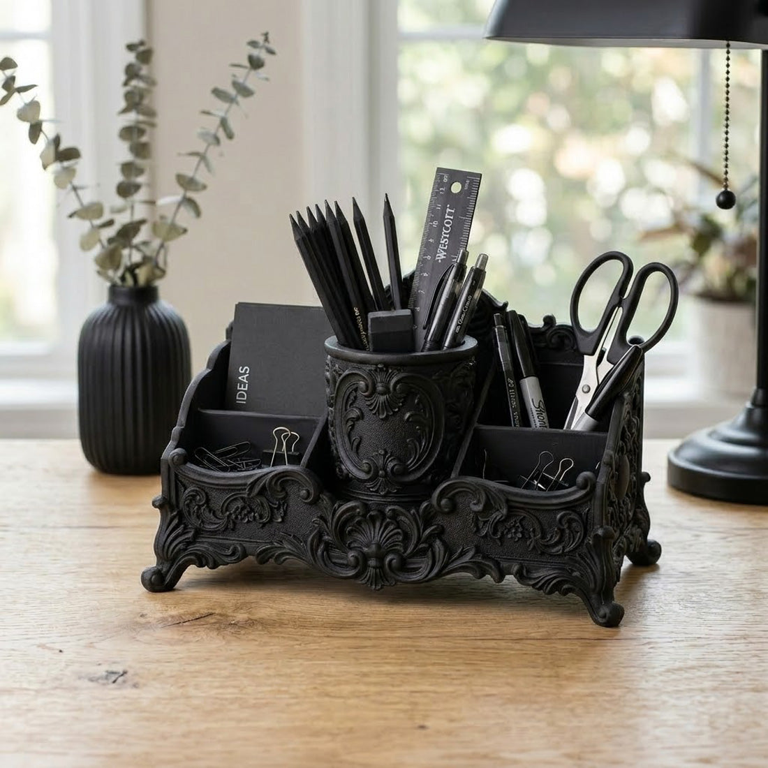 Black baroque desk organizer with ornate raised details and compartments for stationery